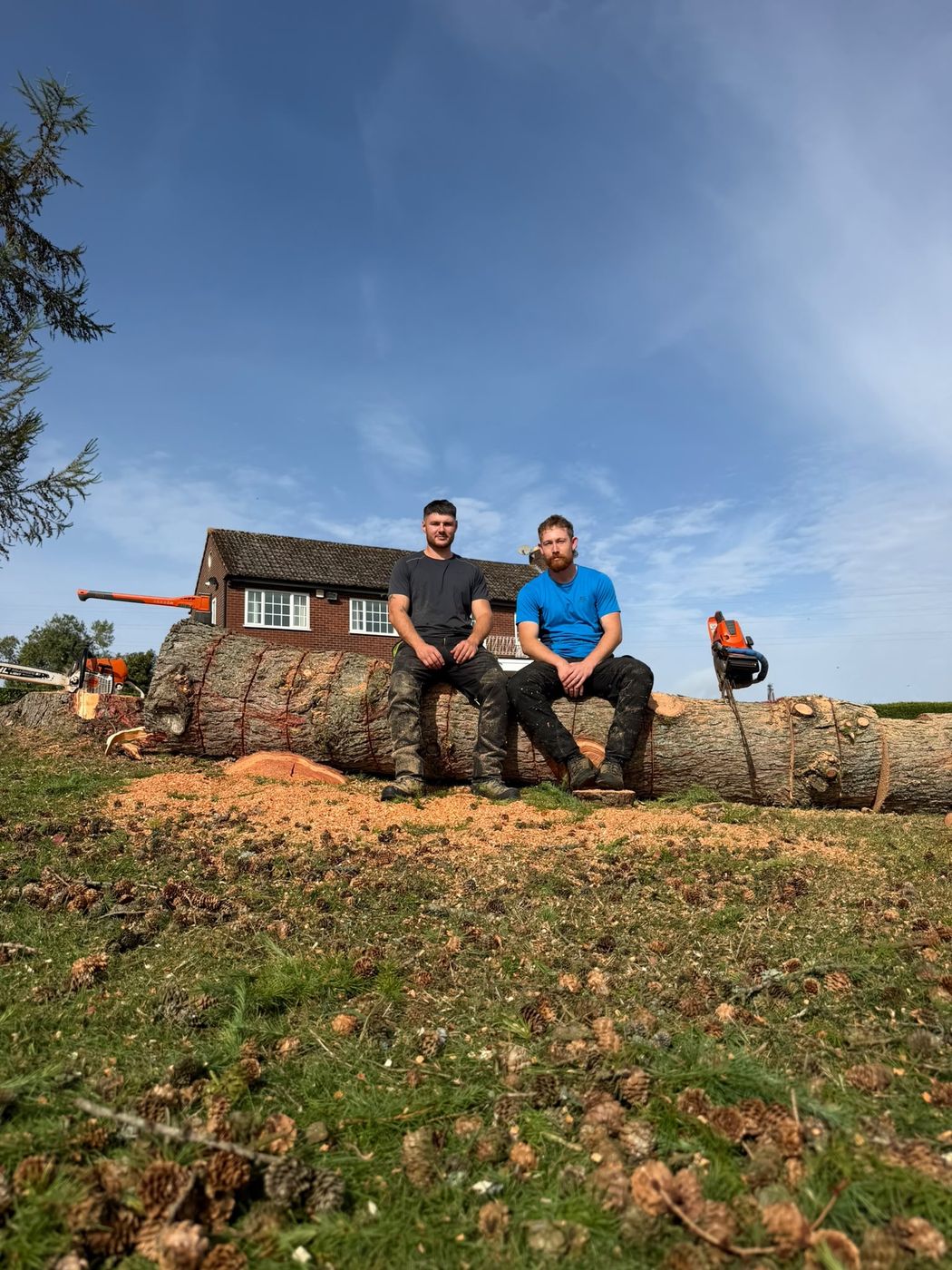 Billy Harley and Matt Stanley sitting on a felled larch trunk
